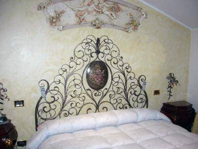 Wrought iron bed with decorated headboard and centre medallion
